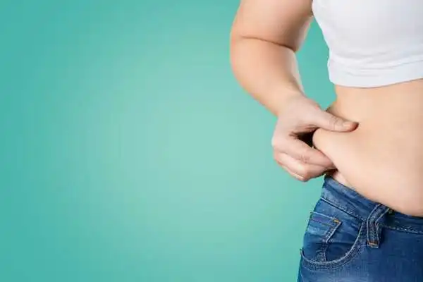 Image of woman pinching her love handles to show weight gain Windsor